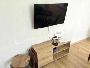 a flat screen tv on a wall with a wooden cabinet at DAMIEN apartments in Ohrid