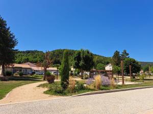a view of a park with trees and a road at F2 neuf grande terrasse chemin de Stevenson proche Le Puy in Coubon
