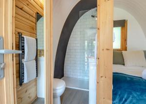 a bathroom with a bed and a toilet in a room at Apple Mount Retreat in Preston +3 photos
