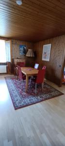 a dining room with a wooden table and chairs at Apartmenthaus Kreuzbuche in Flühli