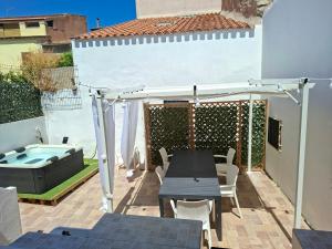 a patio with a table and a hot tub at Su ciaccu in Nulvi