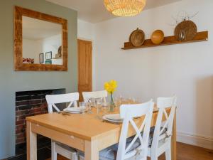a dining room table with white chairs and a mirror at Loreto in Freshwater
