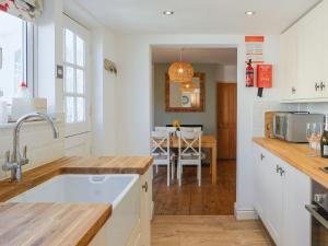 a kitchen with a sink and a dining room at Loreto in Freshwater +9 photos