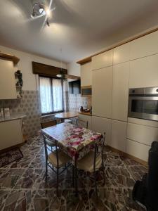 a kitchen with a table and chairs in a room at La Terrazza sul Trebbia in Ottone