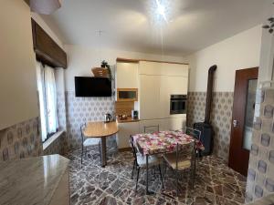 a kitchen with a table and a dining room at La Terrazza sul Trebbia in Ottone