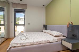 a bedroom with a bed with a stuffed elephant on it at Elefante 10 - Donja Lastva in Donja Lastva +12 photos