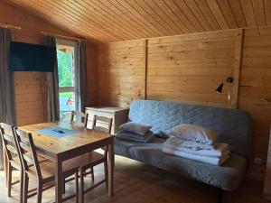 a living room with a couch and a wooden table at Domki i pokoje POD KOGUTEM - kwatery prywatne in Stegna