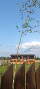 a wooden house with a fence in front of it at Raj nad Narwią in Zatory