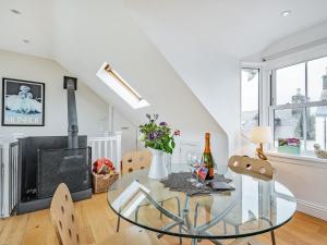 a dining room with a glass table and a fireplace at Killantrae Burn in Port William