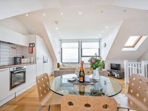 a kitchen and living room with a glass table and chairs at Killantrae Burn in Port William +16 photos