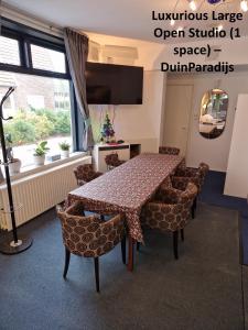 a dining room with a table and chairs at DuinVliet - Zandvoort Dunes & Free Parking in Bentveld