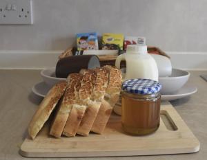 a cutting board with bread and a jar of peanut butter at Willow View Streamside Retreat near Kynren Durham in Newton Aycliffe