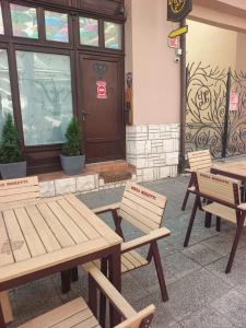 a group of tables and benches in front of a building at elefant in Baia Mare