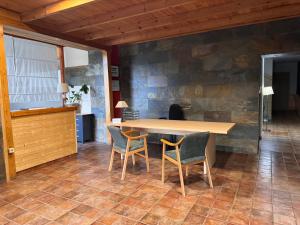 a table and chairs in a room with a stone wall at Hotel Casa Eira B&B in La Molina