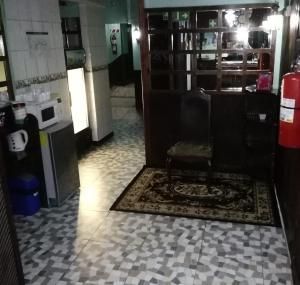 a room with a chair sitting on a tiled floor at Hospedaje del norte in Quesada +6 photos