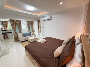 a bedroom with a large bed and a living room at Areeya Khao Khad Aoyon Beach in Ban Ao Makham