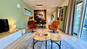 a living room with a table and chairs and a tv at Cube & Quiet - Where nature meets comfort in Haarle