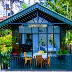 a small blue house with a table and chairs at Blooming Hill Cabin Ella in Ella