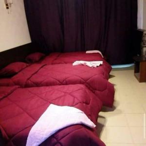 two beds in a room with red comforter at AL Waha Cairo Hotel in Cairo