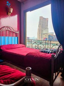 a bedroom with two beds and a large window at AL Waha Cairo Hotel in Cairo
