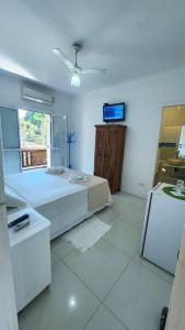 a bedroom with a bed and a tv in it at Pousada Lacosta in Ilhabela +152 photos