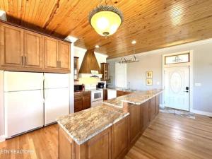 a large kitchen with a white refrigerator and wooden cabinets at Cove Manor in Maynardville