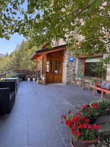 a patio with benches and flowers in front of a building at Hotel Casa Eira B&B in La Molina
