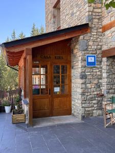 a stone building with a door with a sign on it at Hotel Casa Eira B&B in La Molina