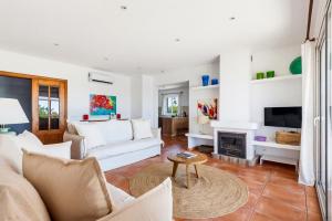 a living room with white furniture and a fireplace at Villa Casa Nova by 3VILLAS in Sant Lluis