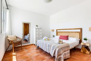 a bedroom with a bed and a chair at Villa Casa Nova by 3VILLAS in Sant Lluis +20 photos