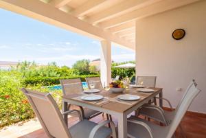 a dining table and chairs on a patio at Villa Casa Nova by 3VILLAS in Sant Lluis