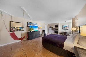 a hotel room with a bed and a flat screen tv at RoofTop Resort - Hollywood Beach, Florida in Hollywood