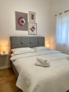 a bedroom with a large bed with two towels on it at Apartments Antini in Solin +36 photos