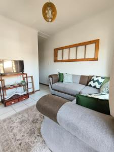 a living room with two couches and a tv at Melvillas in Louis Trichardt