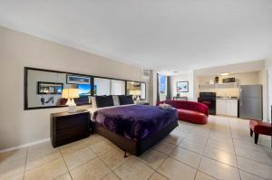 a large bedroom with a bed and a red couch at RoofTop Resort - Hollywood Beach, Florida in Hollywood