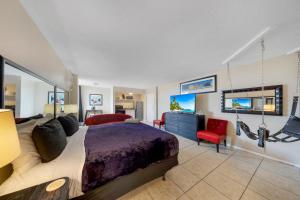 a bedroom with a large bed and red chairs at RoofTop Resort - Hollywood Beach, Florida in Hollywood