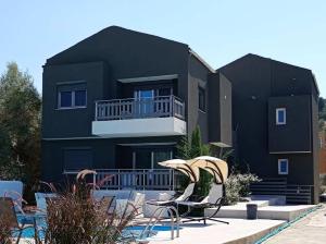 a black apartment building with chairs and a balcony at Alivka Apartments in Apolpaina