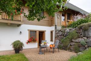 a house with two chairs and a table in front of it at Hirschsprung in Breitnau
