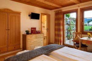 a bedroom with a bed and a dresser and a window at Hirschsprung in Breitnau