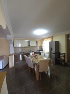 a kitchen with a table with chairs and a refrigerator at Guesthouse Hikari Racha in Bostana +13 photos