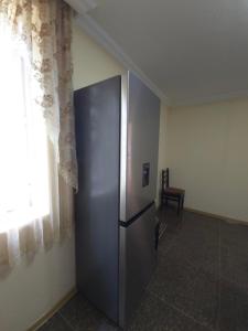 a stainless steel refrigerator in a room with a window at Guesthouse Hikari Racha in Bostana