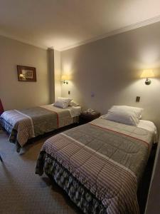 a hotel room with two beds in a room at Hotel Isla Rey Jorge in Punta Arenas