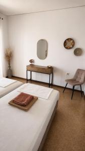 a bedroom with two beds and a table and a chair at Antonios Apartments Stegna in Archangelos