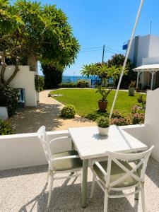 a white table and chairs on a patio at Antonios Apartments Stegna in Archangelos