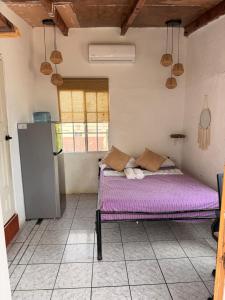 a room with a purple bed and a refrigerator at Karma Muse Hotel in La Libertad