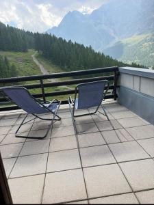 two chairs on a balcony with a view of mountains at Monolocale la terrazza sulla neve-Cervinia in Breuil-Cervinia