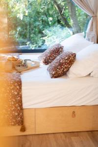 a bed with pillows and a tray of food on it at La Tiny sous les pins in Noves