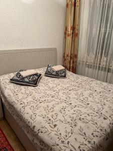 a bed with two pillows on top of it at Keremeti guest house in Dzhangyaryk