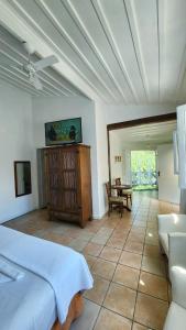 a bedroom with a bed and a couch and a table at Pousada Lacosta in Ilhabela