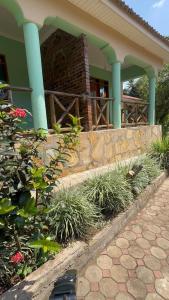 a house with blue columns and plants in front of it at Njaro Haven in Weru Weru